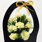 8 Yellow Carnations in Black FNP Sleeve Bag